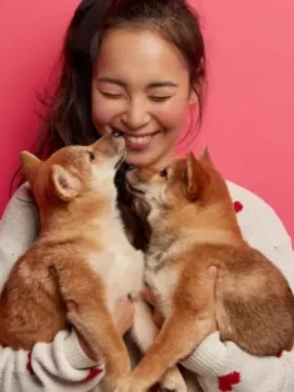 smiling-young-woman-with-two-puppies