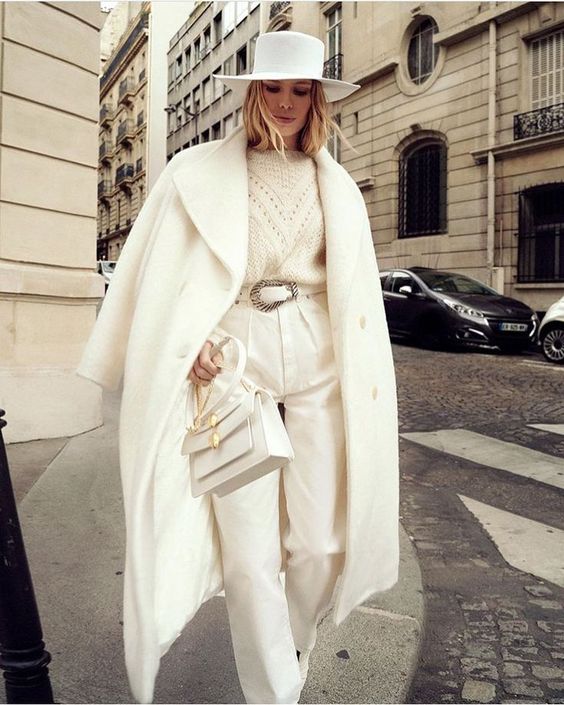 a monochromatic white winter outfit with a sweater pants boots a coat a hat a bag and a belt | MercerOnline