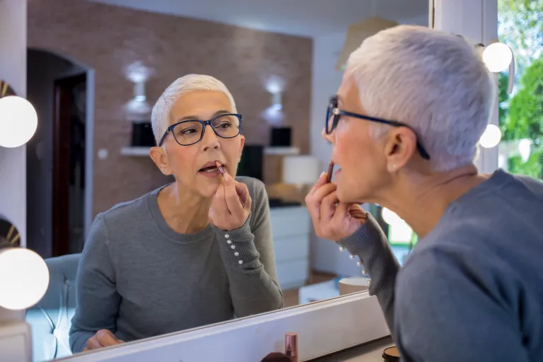 mature woman short gray hair applying lip liner 1 | MercerOnline