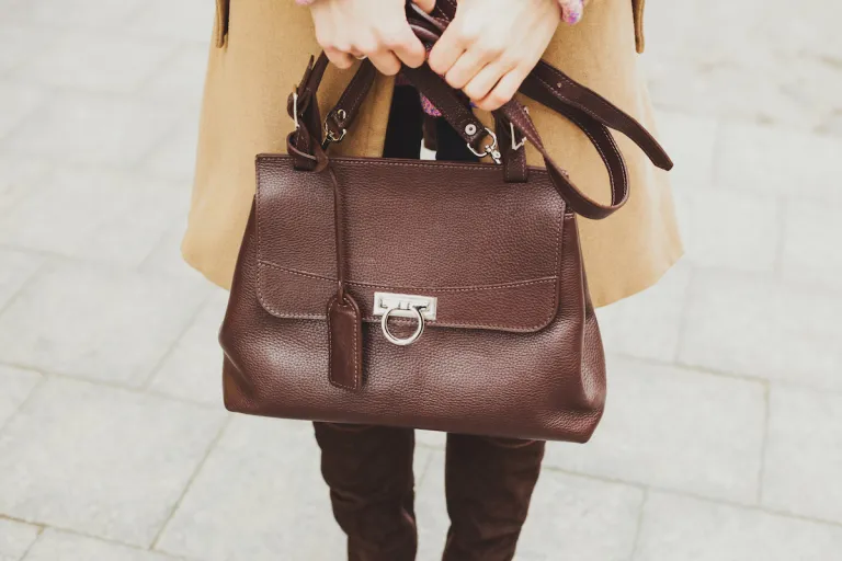 woman holding brown purse with camel colored coat | MercerOnline